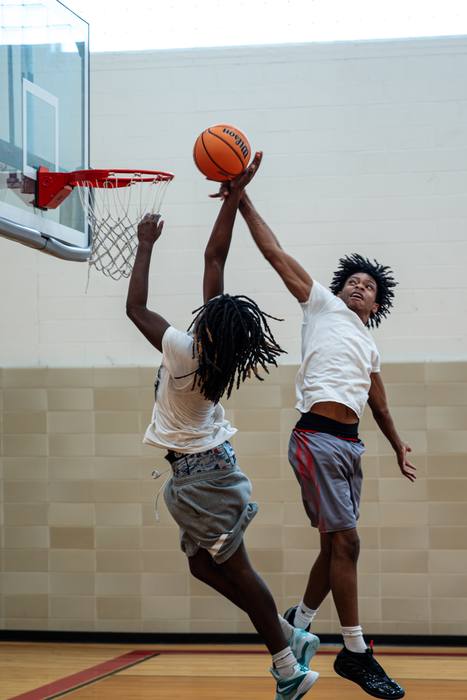 Two players going up at the rim for a block